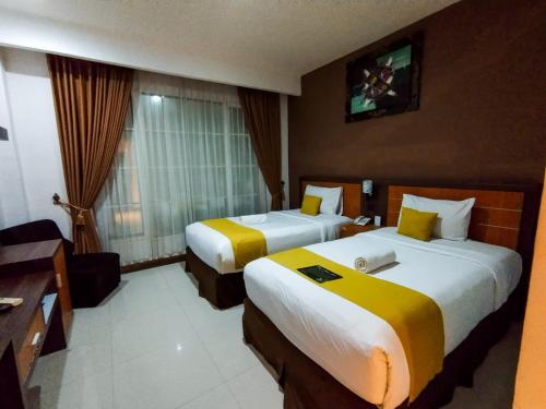 Habitación de hotel con 2 camas y TV en Green Hayaq Hotel, en Selong