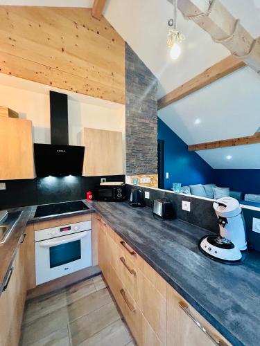une cuisine avec des armoires en bois et un comptoir dans l'établissement Chez Alixe - Appartement avec terrasse, à Gérardmer