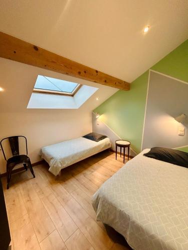 une chambre mansardée avec deux lits et une lucarne dans l'établissement Chez Alixe - Appartement avec terrasse, à Gérardmer