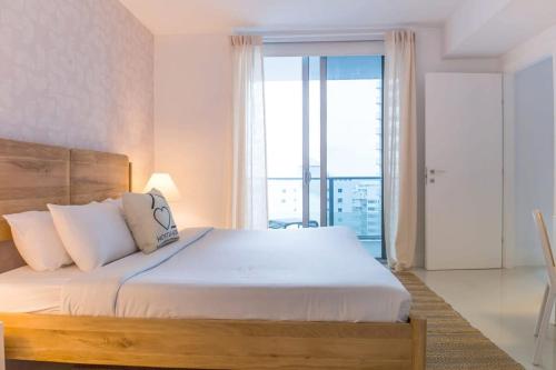 a bedroom with a large bed with a large window at Brickell House Dreams - Luxury Stay and Amenities in Miami