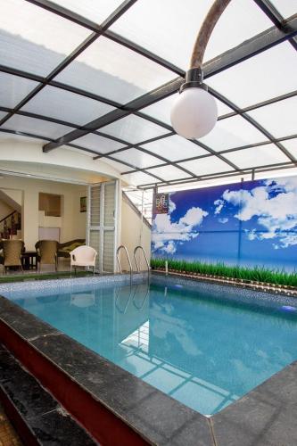 a swimming pool with a roof over it at Nature's retreat villa malavli in Pune