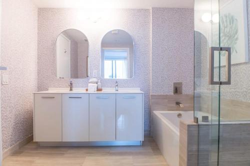 a bathroom with a sink and a tub and a mirror at Brickell House Dreams - Luxury Stay and Amenities in Miami