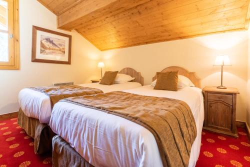 - 2 lits dans une chambre d'hôtel dotée de plafonds en bois dans l'établissement Résidence Les Arcs 1950 Le Village - maeva Home - Appartement 3 Pièces 6 Personnes - Prestige MAE-6614, à Bourg-Saint-Maurice
