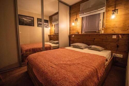 a hotel room with a bed and a mirror at VALERIANE G - Appartement VALERIANE 118 pour 4 Personnes 07 in Valmorel