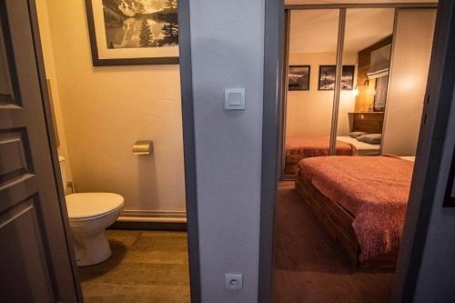 a bathroom with a bed and a toilet in a room at VALERIANE G - Appartement VALERIANE 118 pour 4 Personnes 07 in Valmorel
