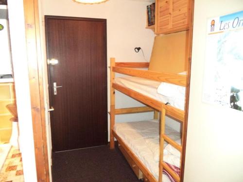 a room with two bunk beds and a door at Résidence Le Meale - Studio pour 4 Personnes 861 in Les Orres