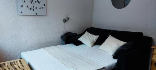 a bed with black and white pillows in a room at Résidence Nova - Studio 2 personnes, proche des pistes et des commerces, au cœur de la station d’Arc 1800 dans le village des Villards MAE-2572 in Arc 1800