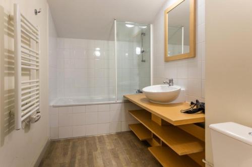 y baño blanco con lavabo y ducha. en Résidence Plagne Lauze - maeva Home - Appartement 3 Pièces 7 Personnes - Pr 44 en Mâcot La Plagne