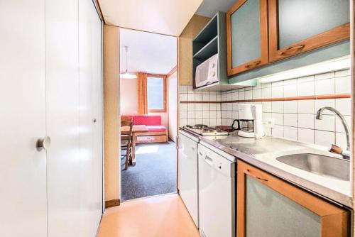 une cuisine avec un évier et un plan de travail dans l'établissement Résidence Les Chalets des Arolles - maeva Home - Studio 5 Personnes - Budget MAE-6424, à La Plagne Tarentaise