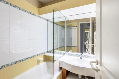 une salle de bain avec un lavabo, une baignoire et un miroir dans l'établissement Résidence Quartier Falaise - maeva Home - Appartement 2 Pièces 6 Personnes - Sélection MAE-0524, à Avoriaz