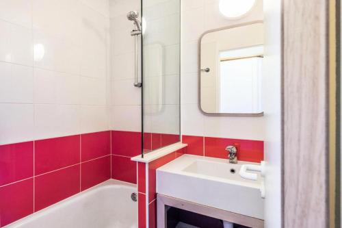 La salle de bains est pourvue d'un lavabo, d'une baignoire et d'un miroir. dans l'établissement Résidence Quartier Falaise - maeva Home - Studio 4 personnes - Sélection 474, à Avoriaz