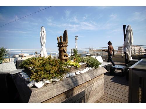 a man standing on top of a balcony with plants at Cit'Hotel Imperial in Sète