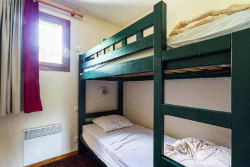 a bunk bed room with two beds and a window at Résidence L'Alpaga - maeva Home - Appartement 2 Pièces 7 Personnes - Budge 524 in La Salle-les-Alpes
