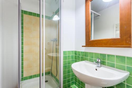 a green tiled bathroom with a sink and a shower at Résidence L'Alpaga - maeva Home - Appartement 2 Pièces 7 Personnes - Budge 524 in La Salle-les-Alpes