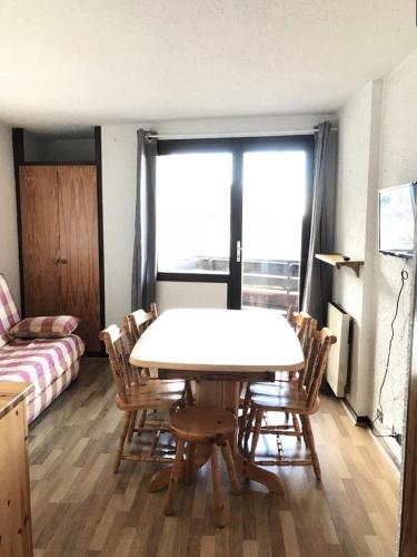 un salon avec une table, des chaises et un canapé dans l'établissement Résidence Le Cairn - COEUR DE STATION Les Orres 1650 - Rés. LE CAIRN - Appart. T2 6 Pers. MAE-6461, aux Orres