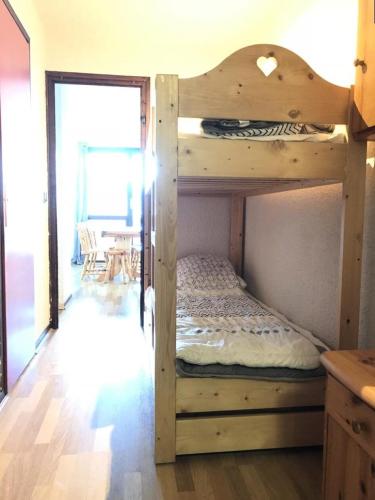 Ce lit superposé en bois se trouve dans un dortoir doté d'une table. dans l'établissement Résidence Le Cairn - COEUR DE STATION Les Orres 1650 - Rés. LE CAIRN - Appart. T2 6 Pers. MAE-6461, aux Orres