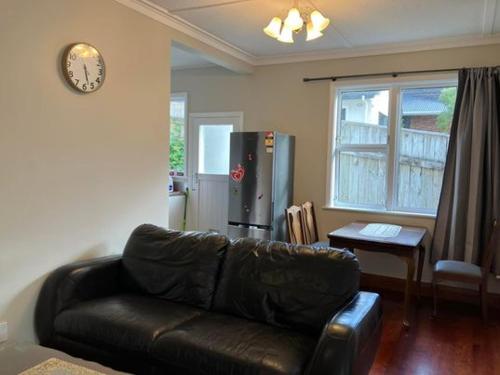 salon z czarną skórzaną kanapą i stołem w obiekcie Wellington single bedroom w mieście Wellington