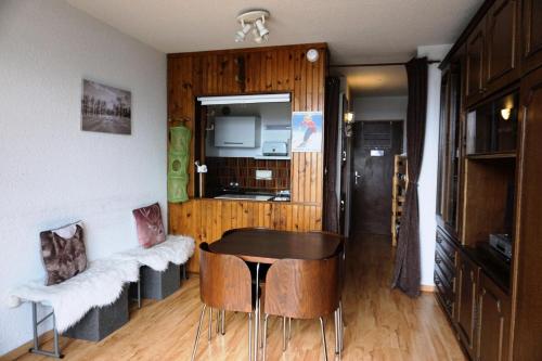 une chambre avec une table et une chaise ainsi qu'une cuisine dans l'établissement Résidence Vallonpierre B - Studio cabine 4 personnes MAE-2819, à Orcières