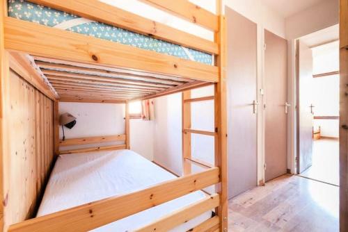 ein Schlafzimmer mit Etagenbetten in einem winzigen Haus in der Unterkunft Résidence Les Mélèzes - maeva Home - 2 Pièces 6 Personnes - Confort 144 in Huez