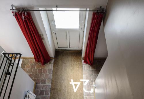 SérisにあるLodge de Loire - rive droite - proche Chambordの赤いカーテンと窓付きのドアが備わる客室です。