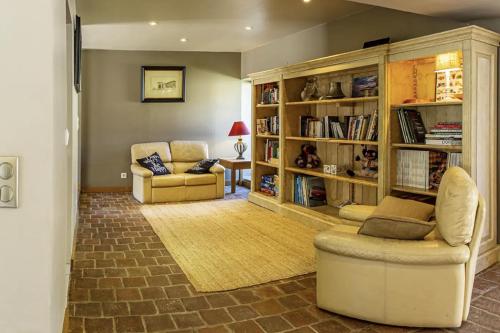 - un salon avec deux chaises et une étagère dans l'établissement Lodge de Loire - rive droite - proche Chambord, à Séris