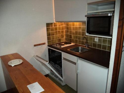 une petite cuisine avec un évier et un micro-ondes dans l'établissement Résidence Le Meale - CENTRE-STATION Les Orres 1650 - Rés. MEALE - Studio 4 personnes MAE-6451, aux Orres