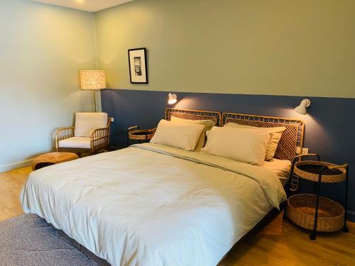 a bedroom with a large bed and a chair at Forget Me Not Boutique Bed & Breakfast Hua Hin in Hua Hin
