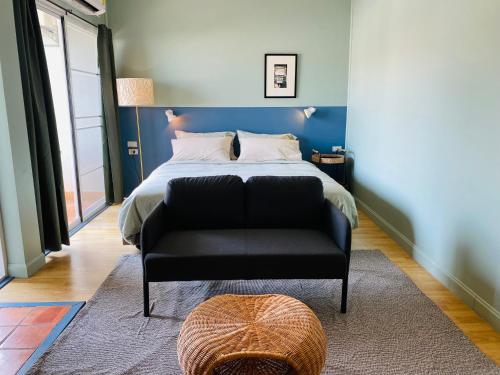 a bedroom with a bed and a black chair at Forget Me Not Boutique Bed & Breakfast Hua Hin in Hua Hin