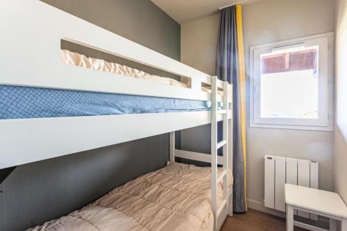 une chambre avec deux lits superposés et une fenêtre dans l'établissement Résidence Le Thabor - maeva Home - Appartement 3 Pièces 6 Personnes - Prestige MAE-9204, à Le Désert