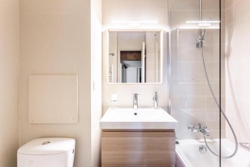 une salle de bain avec un lavabo, des toilettes et un miroir dans l'établissement Résidence Le Thabor - maeva Home - Appartement 3 Pièces 6 Personnes - Prestige MAE-9204, à Le Désert