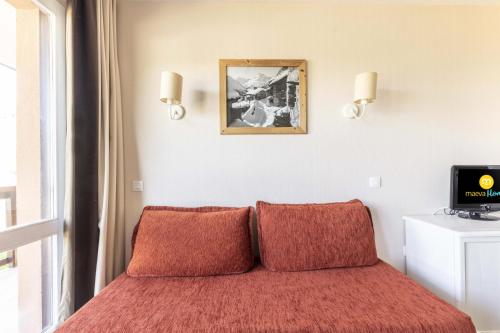 um quarto com uma cama com duas almofadas vermelhas em Résidence Le Thabor - maeva Home - Appartement 2 Pièces 5 Personnes - Sél 794 em Le Désert