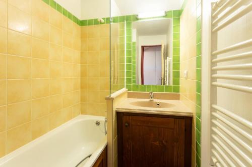 une salle de bain avec un lavabo et une baignoire dans l'établissement Résidence L'Alpaga - maeva Home - Appartement 2 Pièces 7 Personnes - Confort MAE-9874, à La Salle Les Alpes