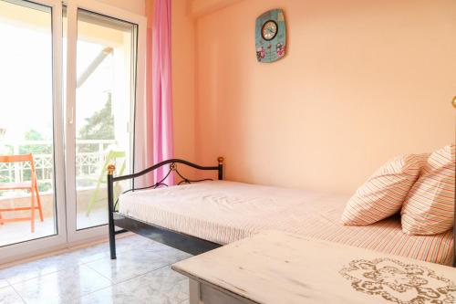 een slaapkamer met een bed en een klok aan de muur bij Pepi's Cozy Apartment in Alexandroupoli