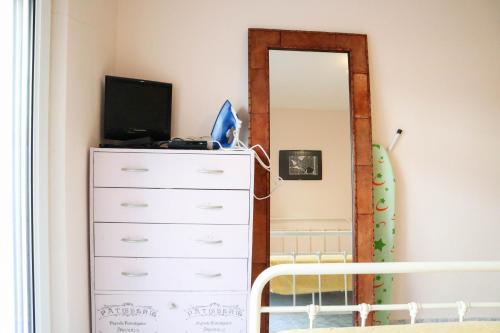 een slaapkamer met een dressoir en een spiegel bij Pepi's Cozy Apartment in Alexandroupoli