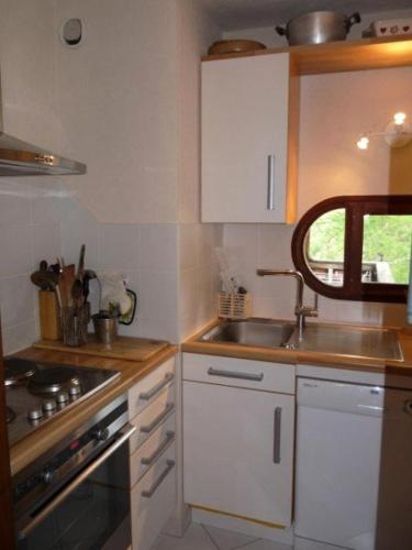 une cuisine avec des armoires blanches et un évier dans l'établissement Résidence L'horizon - Appartement T3 8 personnes - résidence HORIZON MAE-6611, aux Orres