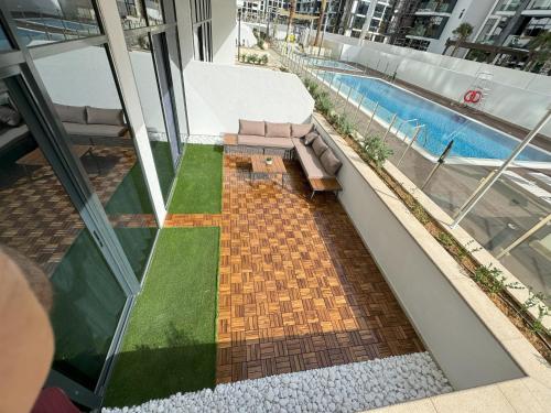 un balcón con piscina y un banco en un edificio en Luxurious Stays - Elevate Your Stay at Azizi Riviera 26, en Dubái