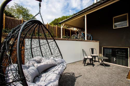 un columpio en un patio con una silla y una mesa en Suite Dreams, en Groesbeek