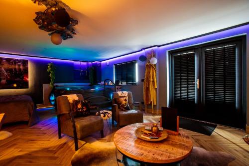 sala de estar con iluminación púrpura y mesa en Suite Dreams, en Groesbeek