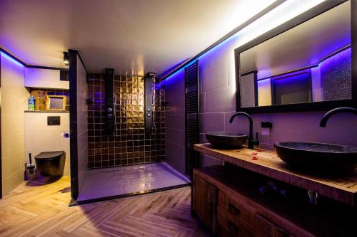 baño con 2 lavabos y ducha con luces moradas en Suite Dreams, en Groesbeek