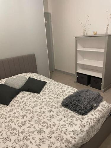 a bedroom with a bed with a black and white blanket at Bel appartement / Troyes in Saint-Parres-aux-Tertres