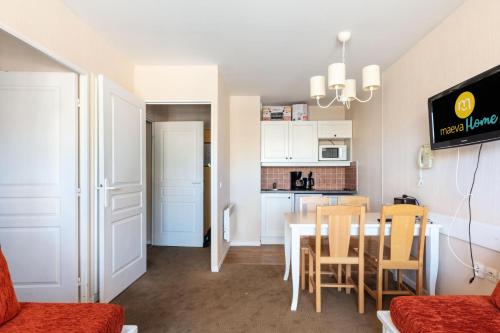une cuisine et une salle à manger avec une table et des chaises dans l'établissement Résidence Le Thabor - maeva Home - Studio 4 Personnes - Sélection MAE-0044, à Le Désert