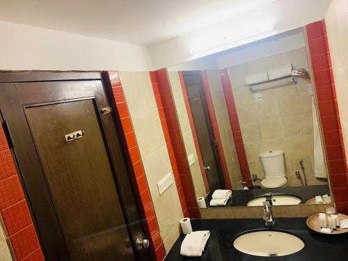 a bathroom with a sink and a mirror at The Riverview Retreat Corbett by Leisure Hotels in Garjia
