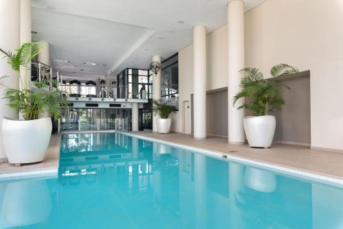 una piscina con macetas en un edificio en Century City Boutique Apartments, en Ciudad del Cabo