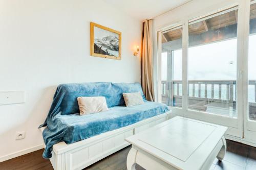 un salon avec un canapé bleu et une table dans l'établissement Résidence Le Thabor - maeva Home - Appartement 2 Pièces 5 Personnes - Confort MAE-6374, à Le Désert