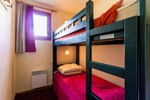- une chambre avec 2 lits superposés et un lit rouge dans l'établissement Résidence L'Alpaga - maeva Home - Appartement 2 Pièces 5 Personnes - Budget MAE-9994, à La Salle Les Alpes