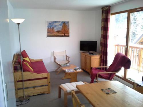 uma sala de estar com um sofá e uma mesa em Les Chalets D'arrondaz - 3 Pièces pour 6 Personnes 38 em Modane
