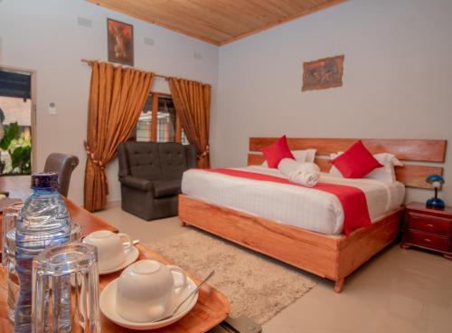 ein Schlafzimmer mit einem Bett und einem Tisch mit Geschirr darauf in der Unterkunft SHERBOURNE LODGE in Kitwe