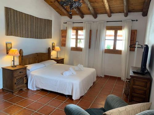 una camera con due letti, una TV e finestre di Villa Calabasas ad Almuñécar