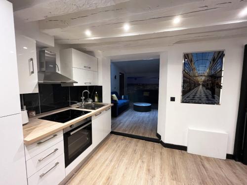une cuisine avec des armoires blanches et un salon dans l'établissement Urban Flat 175 - Loft St Denis, à Paris