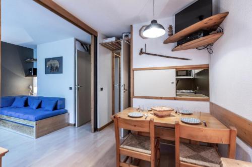 a living room with a table and a blue couch at Résidence LA TRAVERSE - Appartement TRAVERSE 10 pour 4 Personnes 32 in Les Coches
